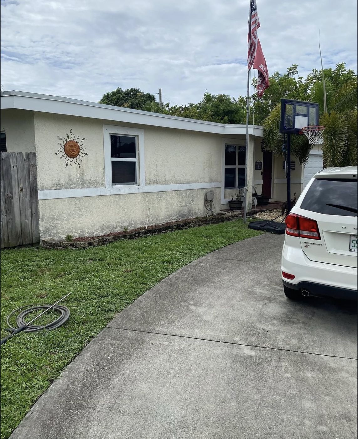 Home exterior before repaint, peeling and stained stucco, Orlando FL